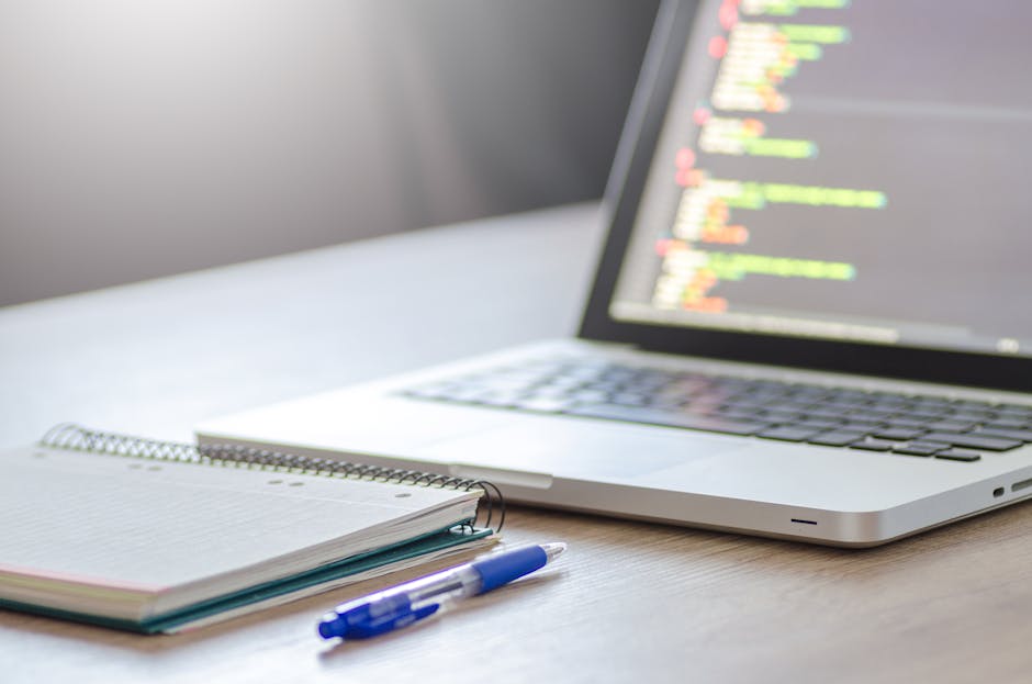 A close-up digital screen displaying lines of HTML code with various elements such as tags, attributes, and text in multiple colors, including red, green, blue, and white. The code features keywords l
